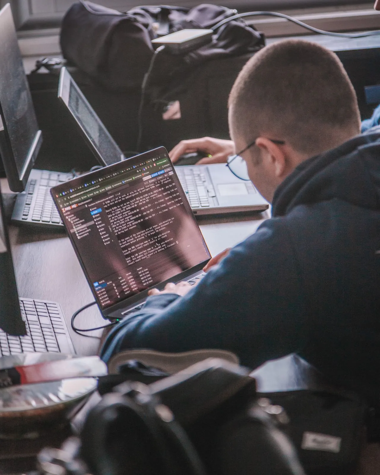 Adulte en reconversion suivant une formation cybersécurité en e-learning, écran de console et code visible